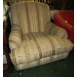 BEIGE STRIPED UPHOLSTERED ARMCHAIR STANDING ON BRASS CASTORS