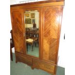 A large mahogany wardrobe, late 19th century, a single central mirrored door with quarter veneer