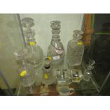 SHELF OF GLASSWARE INCLUDING STOPPERED DECANTERS (ONE WITH WHITE METAL COLLAR) AND TWO CANDLE