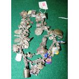 BRACELET OF ABOUT FORTY-FOUR CHARMS, SOME ENAMELLED, SOME STAMPED 'STERLING', 'SILVER', ETC (