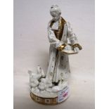 BING AND GRONDAHL PORCELAIN FIGURE OF ROBED MAN FEEDING CHICKENS, WHITE WITH GILDING, ON CIRCULAR