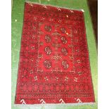 SMALL RED GROUND PATTERNED WOVEN WOOLLEN FLOOR RUG WITH TASSELLED ENDS