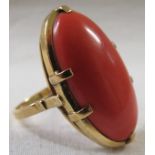 A dress ring set with a very large oval opaque red cabouchon stone (26mm x 14mm) in a claw