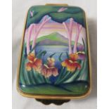 Moorcroft enamel oblong pill box with hinged lid, blue body, the lid painted with landscape and