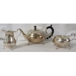 A George V three-part silver tea set with barbed rims and scrolled handles, comprising a teapot with