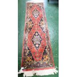 RED GROUND PATTERNED FLOOR RUNNER WITH TASSELLED ENDS