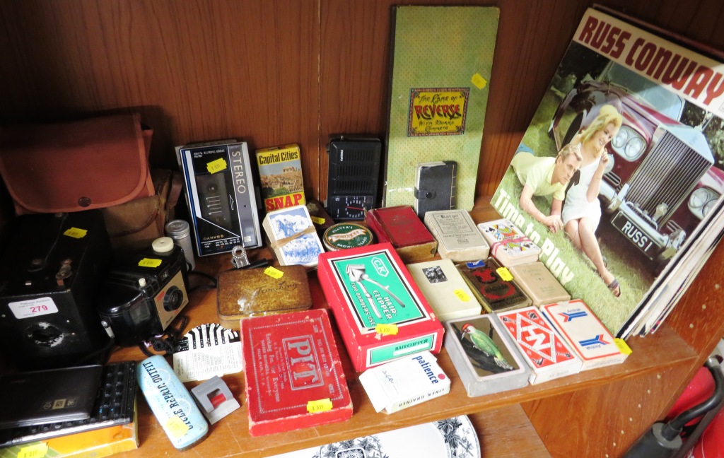 SHELF OF VINTAGE ITEMS INCLUDING BROWNIE CAMERA, PLAYING CARDS, VINYL RECORDS, COMMERCIAL TINS,