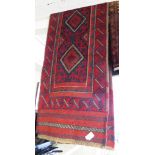 RED GROUND HAND KNOTTED WOOLLEN FLOOR RUG WITH FOUR CENTRAL MEDALLIONS (236CM X 59CM)