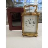 A brass serpentine cased carriage clock raised on bun feet, the dial signed Cooper Worcester, the