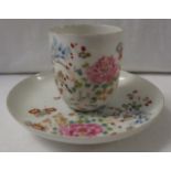 A fine white porcelain cup and saucer enamelled in the famille rose palette with flowers and