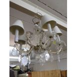 A five-branch lustre electric chandelier with bevelled droplets, glass florettes, bowls and stem,