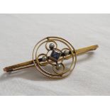 A bar brooch set with a small square cut pale sapphire (4mm x 4mm) and four seed pearls in loop