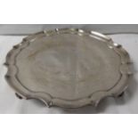 A silver piecrust circular tray on four scroll feet, the top with 1952 presentation inscription