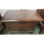 An early 19th century oak stool or coal box with hinged lid, carved to front panel with foliate