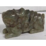 Miniature figure of a mythical dog carved from jade-type green stone, height 23mm, length 42mm