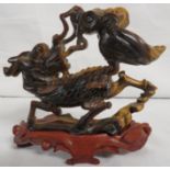 Carved tigers eye stone mythological figural group, deer or Qilin with lion's head fending off a