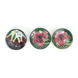 Moorcroft pair coasters decorated in the anemone design and another coaster,