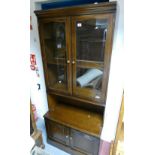 A stag slim display cabinet with two glazed doors above two door base