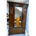 A Victorian burr walnut single door wardrobe with mirrored door flanked by carved panels above