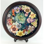 Moorcroft charger decorated in the Carousel design by Rachel Bishop and dated 1996 in wooden frame,
