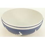 A prestige Wedgwood large footed bowl in white on Portland dark blue dip Jasperware decorated with