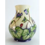 Moorcroft vase decorated with purple flowers and green leaves dated 1999, height 16cm, boxed.