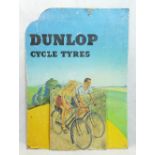 Dunlop Cycle Tyres shop advertising piece on cardboard depicting lady and gentleman on bicycles.
