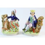 Pair 19th century Staffordshire figures of seated male and female hunters,