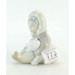 A Lladro figurine of an eskimo child with a polar bear.