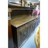 Early twentieth century oak court cupboard with heavily carved panels and protruding elements and