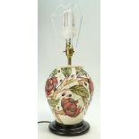 Moorcroft lampbase decorated in the Pirouette breeze design on wood plinth,