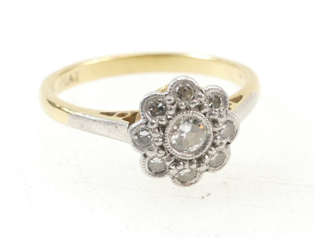 18ct gold and diamond set Daisy ring, central stone surrounded by 8 smaller stones, collet set.