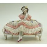 Dresden lace porcelain figure of a lady seated on a sofa,