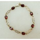 9ct gold ladies bracelet set with seven oval semi precious stones (possibly garnets), 8.