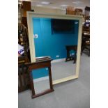 Large over painted bevel edged wall mirror together with similar smaller item (2).
