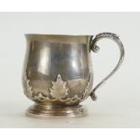 Silver christening mug decorated all around with maple leaves,