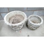 2 stone garden planters, one in a wicker basket design,