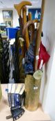 Brass embossed umbrella stand with a collection of walking sticks,