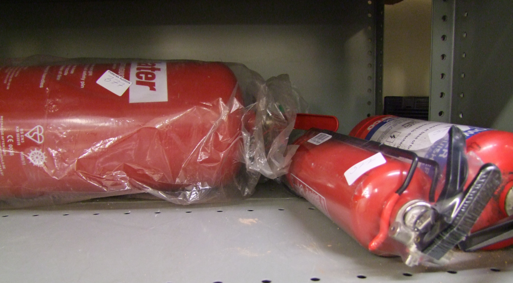 A large fire extinguisher with 2 other smaller examples.