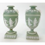 A pair of 19th century Wedgwood green dip Jasperware urns decorated with Dancing Hours Ladies,