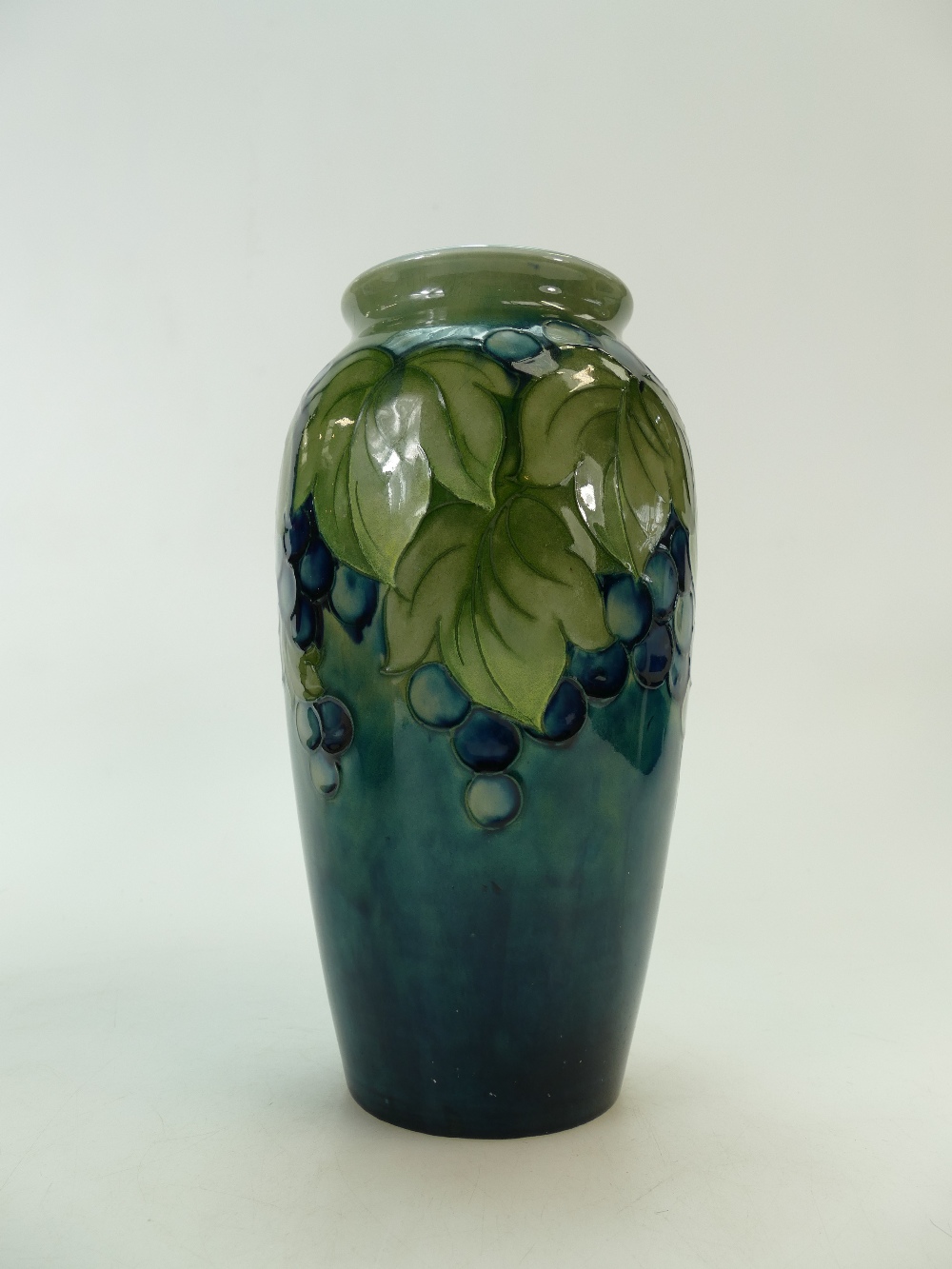 William Moorcroft 1920s vase decorated with the unusual two tone blue & green leaf and berries