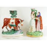 Two Staffordshire spill vases 1 depicting of a cow and 1 with two ladies.
