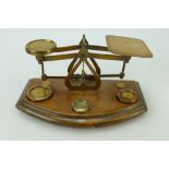 Small set of early 20th century brass postal scales and weights on wooden base. 20cm.