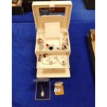 A cream jewellery case containing costume and silver items including - rings, necklaces,