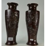 A pair of Japanese Bronze vases with embossed floral decoration. 35cm high. (2).