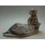 Large Nao figure of a lady reclining on a rock holding a flower, h23cm,