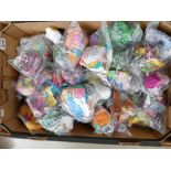 A collection of Mcdonalds happy meal toys, mostly sealed in bags,