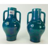 A pair of pottery two handled vases in a