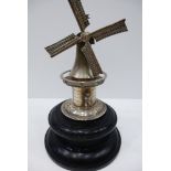 Continentla white coloured metal model of a windmill and a figure on a turned ebony base, 17cm high-