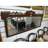 An antique mahogany over mantle mirror having carved gilt decoration with beaded glass